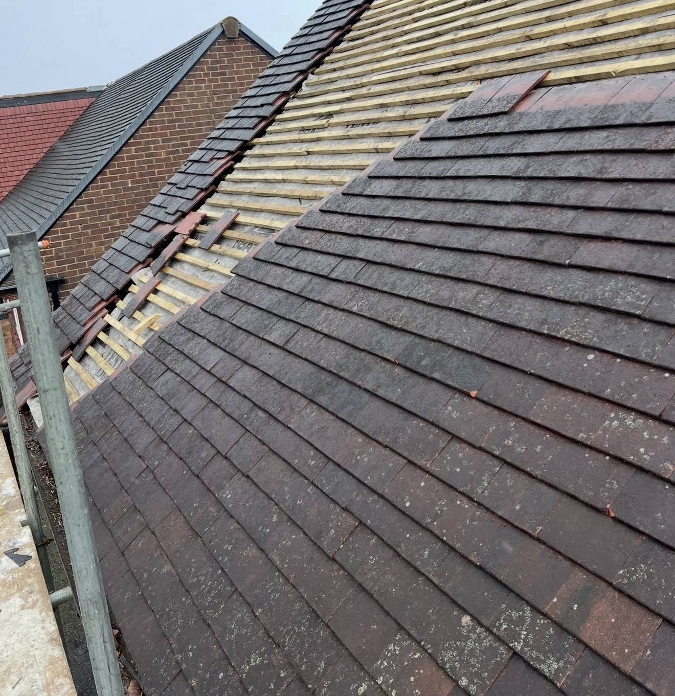 Professional roof repair with plain tiles relaid over new battens