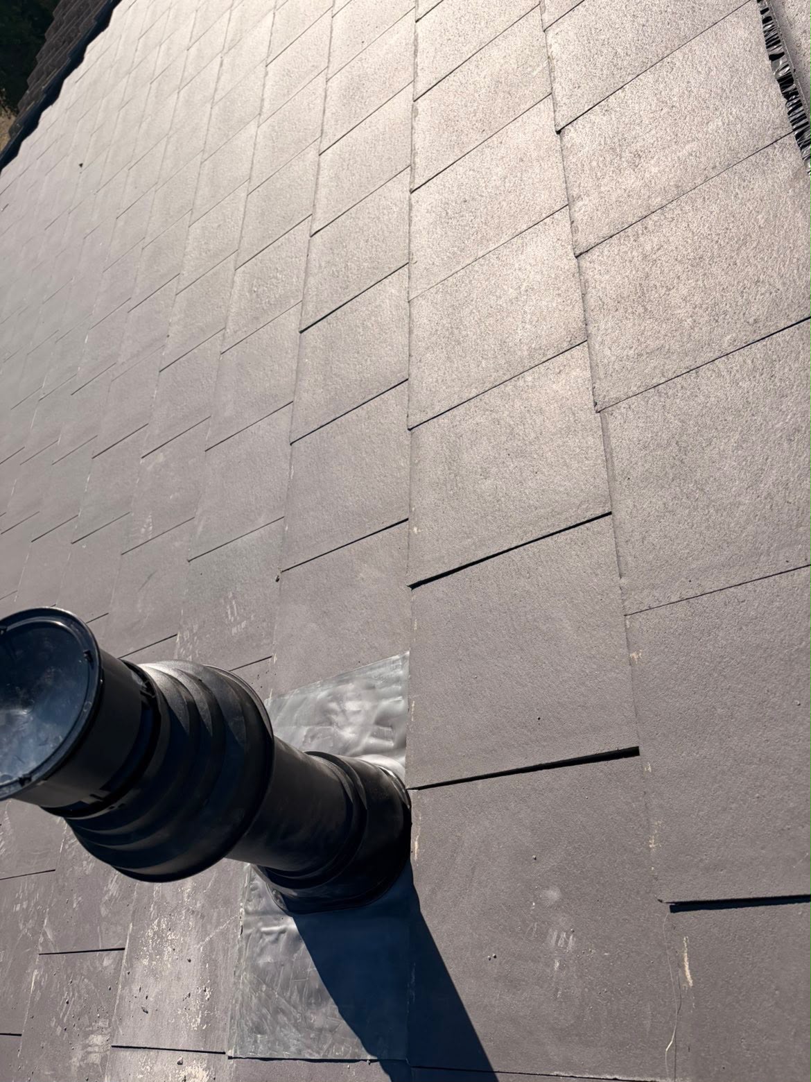 Slate roof with a newly flashed vent pipe, sealed against winter weather